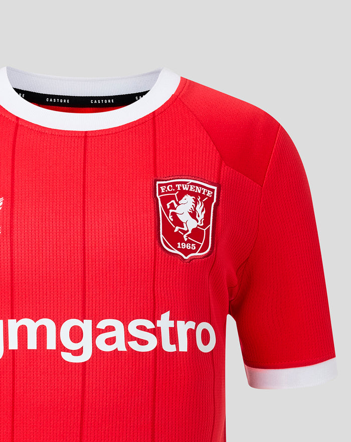 FC Twente home shirt close-up showing red knit fabric white collar crest on chest and partial sponsor lettering