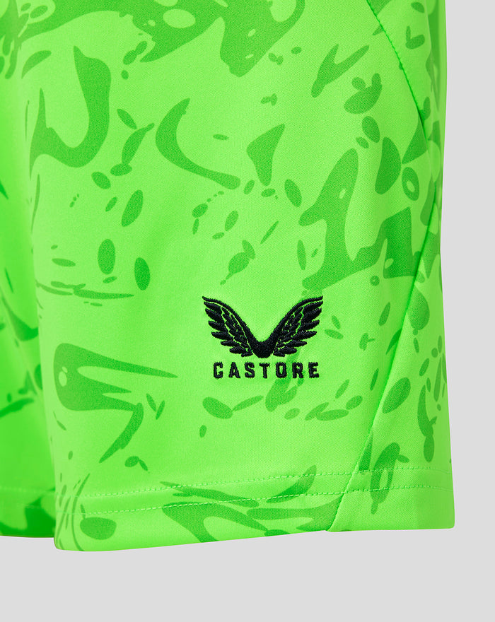 Close-up van neon groene keepershort met Castore logo en zwarte vleugels op de stof.