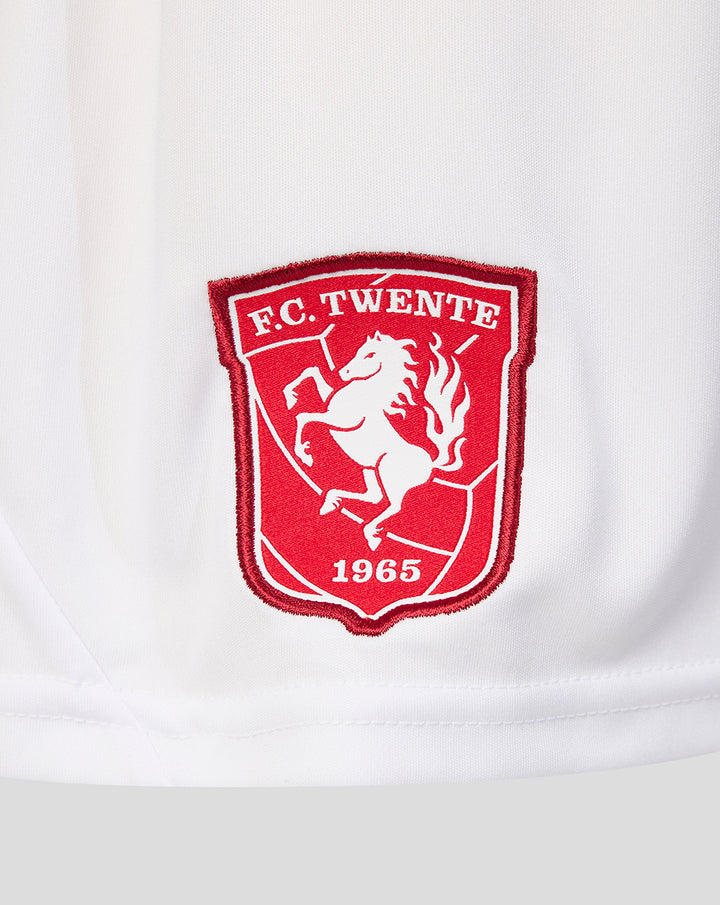 Close up of red FC Twente crest embroidery on white fabric of the shorts.