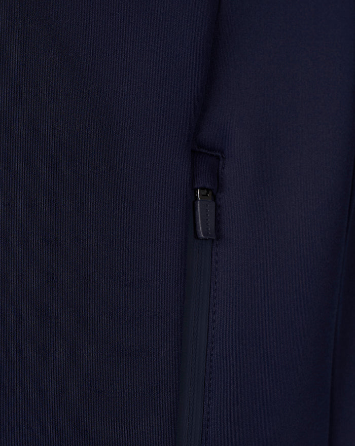 Close-up of navy Travel hoodie showing a zippered side pocket detail.