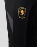 Close-up of left thigh showing gold FC Twente crest on black training pants.