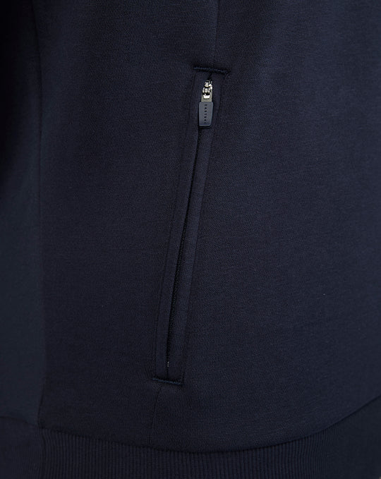 Close-up of navy FC Twente hoodie fabric showing a vertical zip pocket and Castore zipper pull