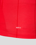 Close-up of red FC Twente home shirt fabric featuring a black Castore authentic product patch near the hem.