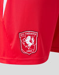 Detail of red FC Twente shorts showing crest patch near the hem