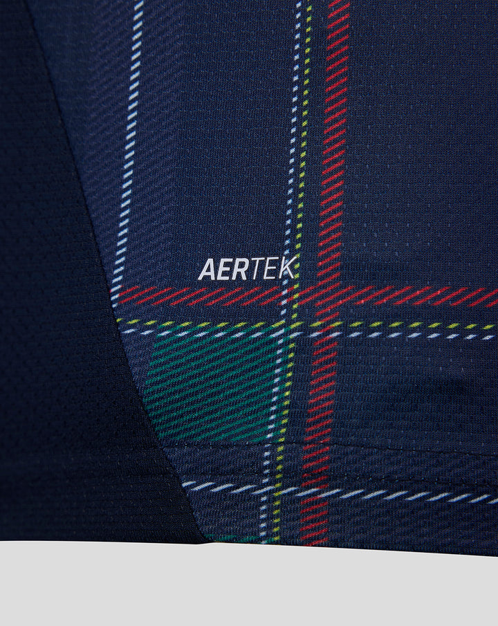 Close-up of navy FC Twente Vierde Shirt fabric showing tartan plaid stripes and AERTEK branding