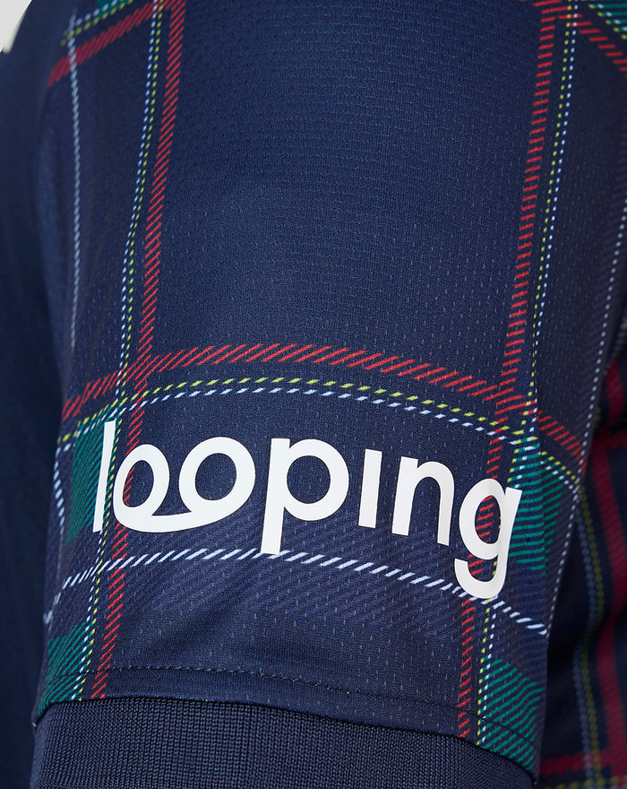 Close up of navy FC Twente fourth shirt fabric with red green tartan pattern and looping branding