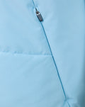 Close-up of zipper and chest seam on light blue training gilet with Castore branding