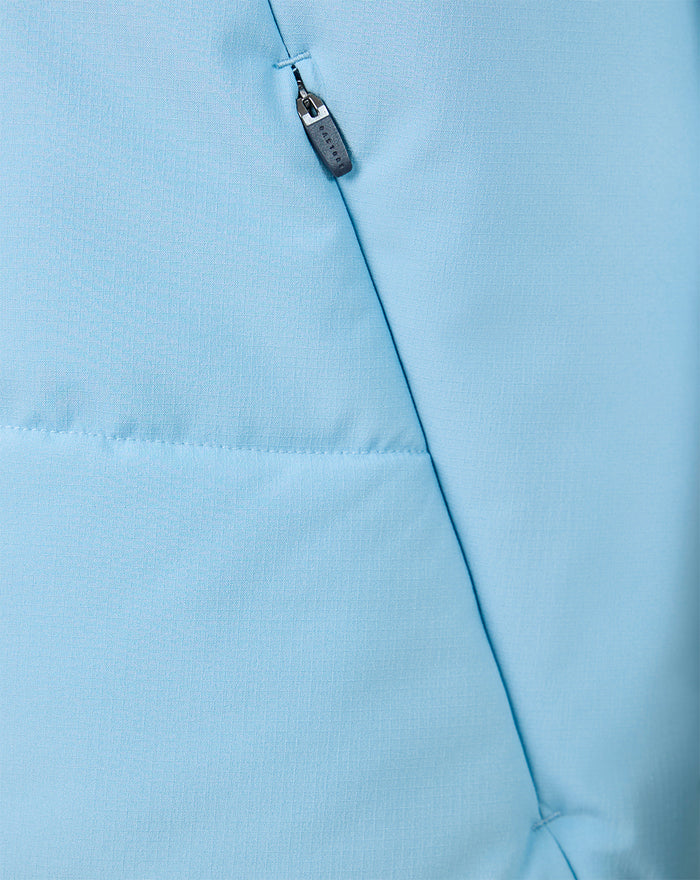 Close-up of zipper and chest seam on light blue training gilet with Castore branding