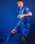 Mannelijke model draagt FC Twente Uitshirt 25/26 MANNEN met blauw stippenpatroon en clublogo op borst