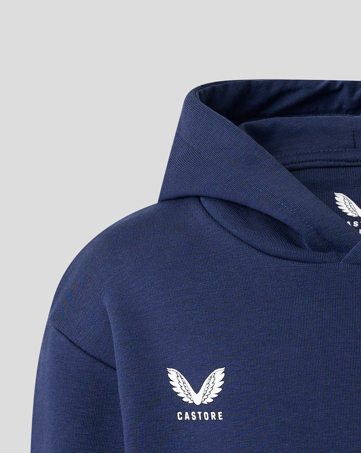 Close-up of navy hoodie shoulder featuring Castore logo and white wing emblem