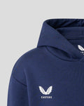 Close-up of navy hoodie shoulder featuring Castore logo and white wing emblem