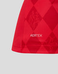 Close up of red FC Twente home shirt fabric with AerTek branding and diamond pattern.