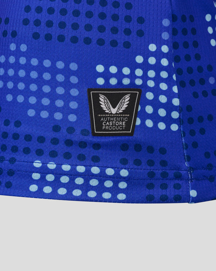 Close-up of blue FC Twente shirt fabric with a dotted pattern and Authentic Castore Product patch.