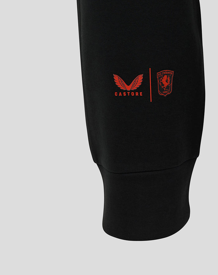 Close-up of black FC Twente Travel pants displaying Castore wings and club crest on the thigh.