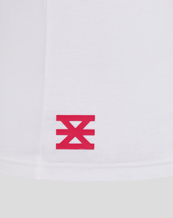 Close up of white fabric with a pink FC Twente logo near the hem