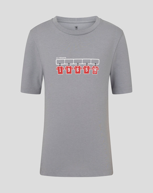 Grey junior FC Twente T shirt with graphic of five red jerseys hanging on a rack.
