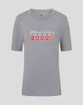 Grey junior FC Twente T shirt with graphic of five red jerseys hanging on a rack.
