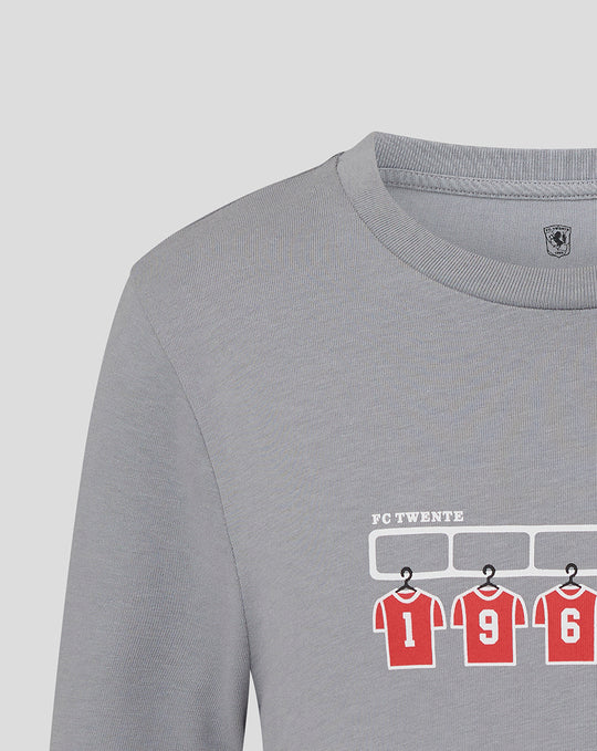 Grey T shirt with FC Twente graphic of red numbered jerseys under a white rack