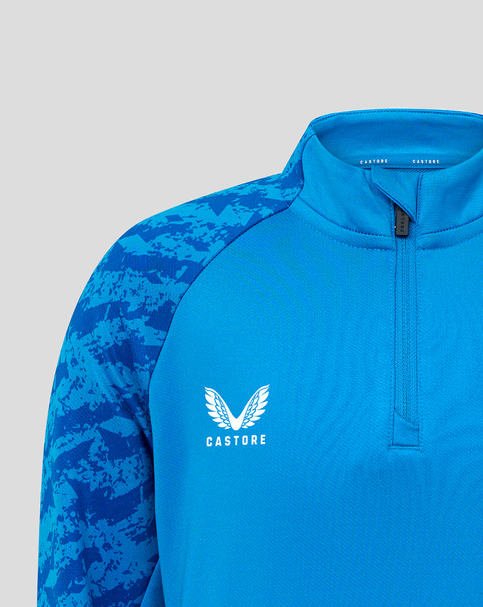 Blue FC Twente junior midlayer top with front zipper and white Castore wing logo on chest.