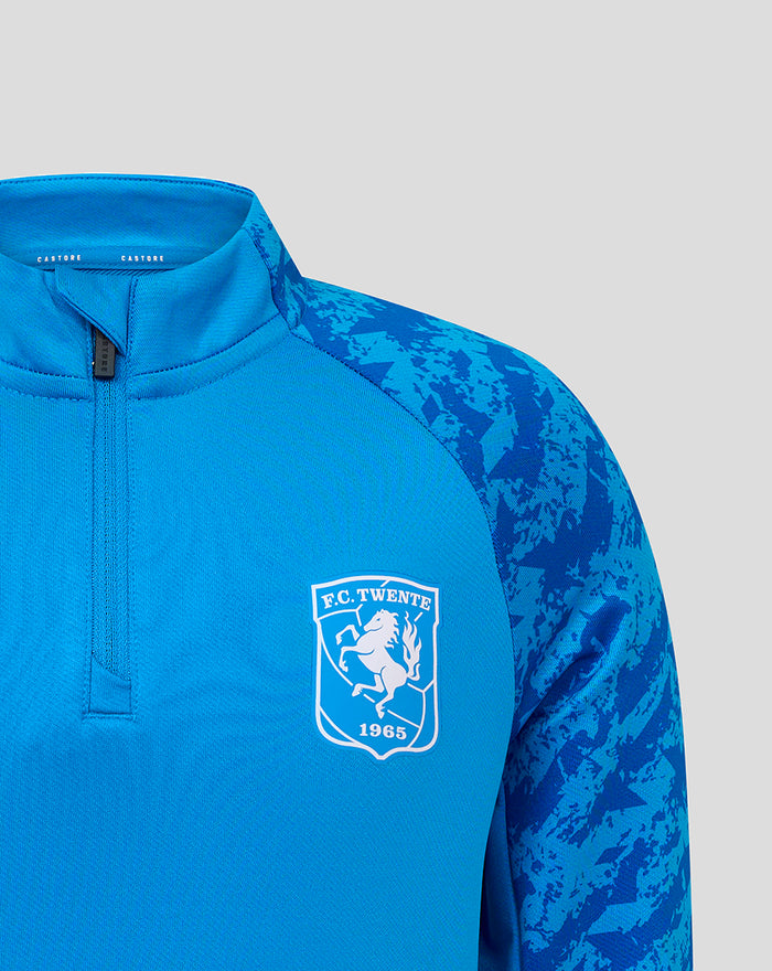 Close-up of blue FC Twente midlayer top showing crest on the chest and the front zipper