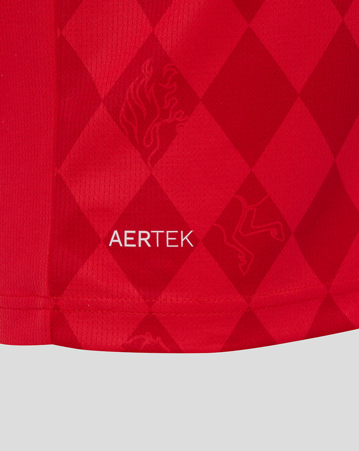 Close up of red FC Twente home shirt fabric with a diamond pattern and AERTEK branding