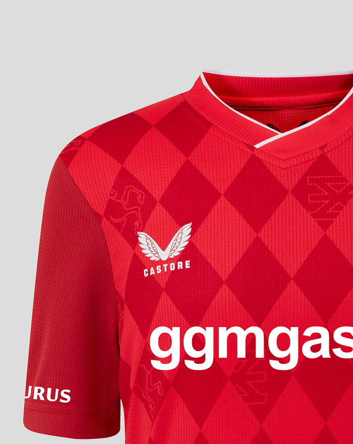 Close-up of FC Twente home shirt 25/26 junior in red diamond pattern with Castore logo on the chest and bold white sponsor lettering.
