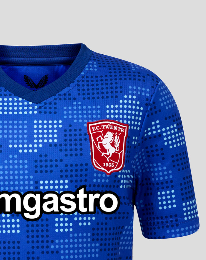 Close up of FC Twente 25/26 junior away jersey in blue with dotted pattern and crest on the chest