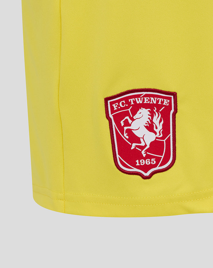 Close up of yellow keeper short showing FC Twente crest on the left leg and curved hem edge.