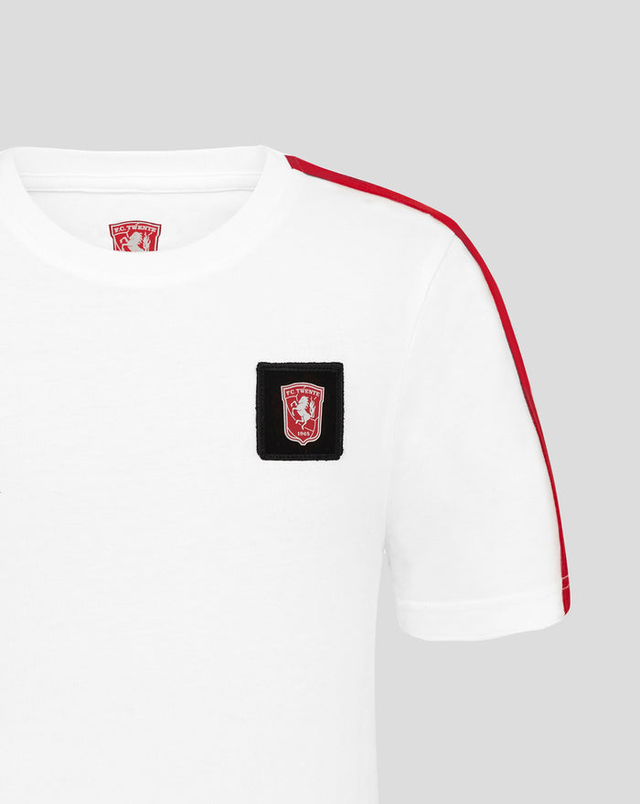 Close up of FC Twente junior white cotton T-shirt showing a black patch crest on chest and black shoulder stripe