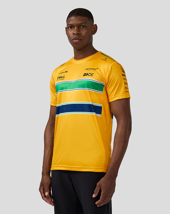Male model wearing bright yellow McLaren Teamwear Senna Monaco T Shirt with green and navy stripe design