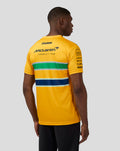 Back view of a man in a yellow Ayrton Senna Monaco T Shirt with green and navy stripes and sponsor logos.