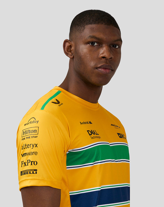 Close up of a model in the yellow Ayrton Senna Monaco T Shirt highlighting chest stripes and sponsor logos.