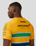 Back view of a bright yellow McLaren Formula 1 Team T shirt with sponsor logos and green white blue horizontal stripes.