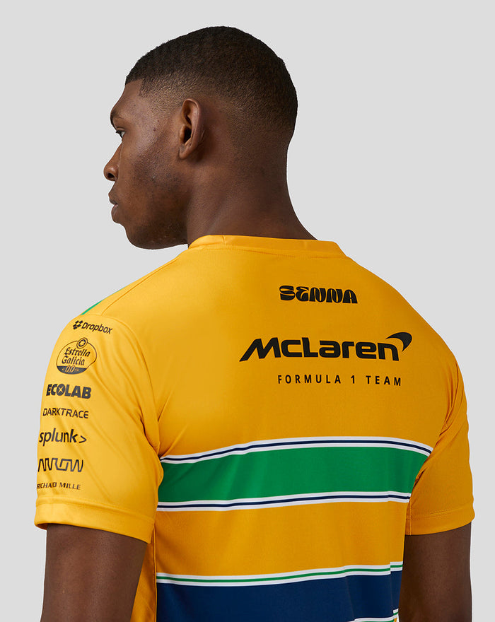 Back view of a bright yellow McLaren Formula 1 Team T shirt with sponsor logos and green white blue horizontal stripes.