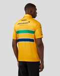 Back view of yellow McLaren Senna Monaco polo featuring sponsor logos and green white navy stripes