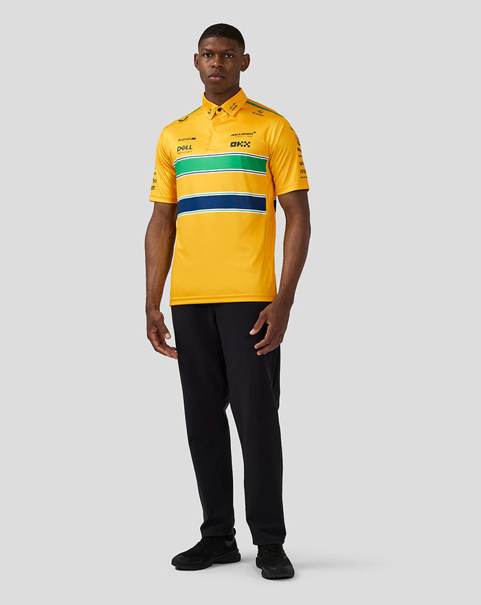 Male model in a yellow McLaren Monaco polo with green white and navy stripes, shown in a full front pose with black pants.