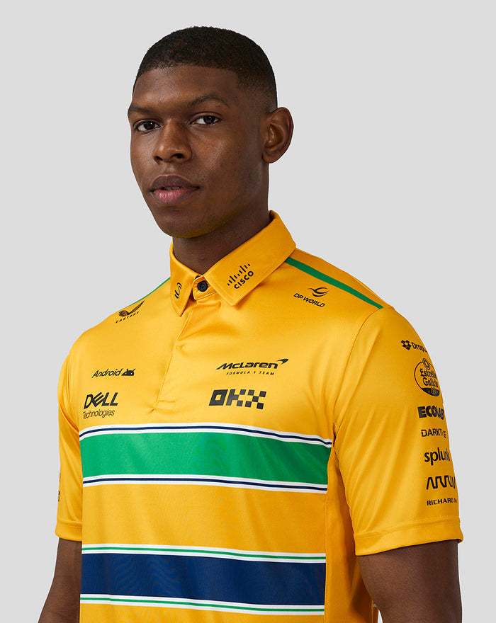 Close up of a male model wearing a yellow McLaren Monaco polo, highlighting the collar and printed sponsor logos.