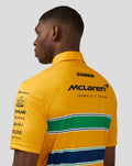 Back view of a male model wearing a bright yellow McLaren Monaco polo with green and blue striped band and sponsor logos.