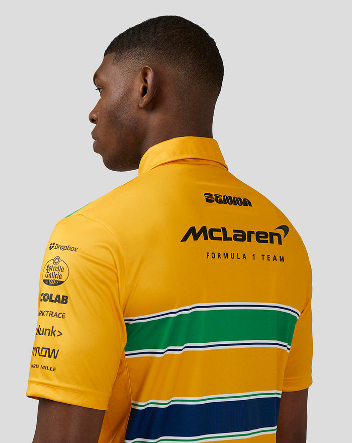 Back view of a male model wearing a bright yellow McLaren Monaco polo with green and blue striped band and sponsor logos.