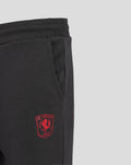 Close up of black junior FC Twente jogger with a red club crest on the thigh near the pocket.