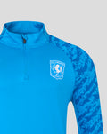 Close-up of blue FC Twente midlayer top with stand-up collar, half zip and club crest on the chest