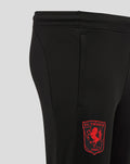 Close-up of the lower leg showing the FC Twente crest on black fabric with a zipper at the hem.