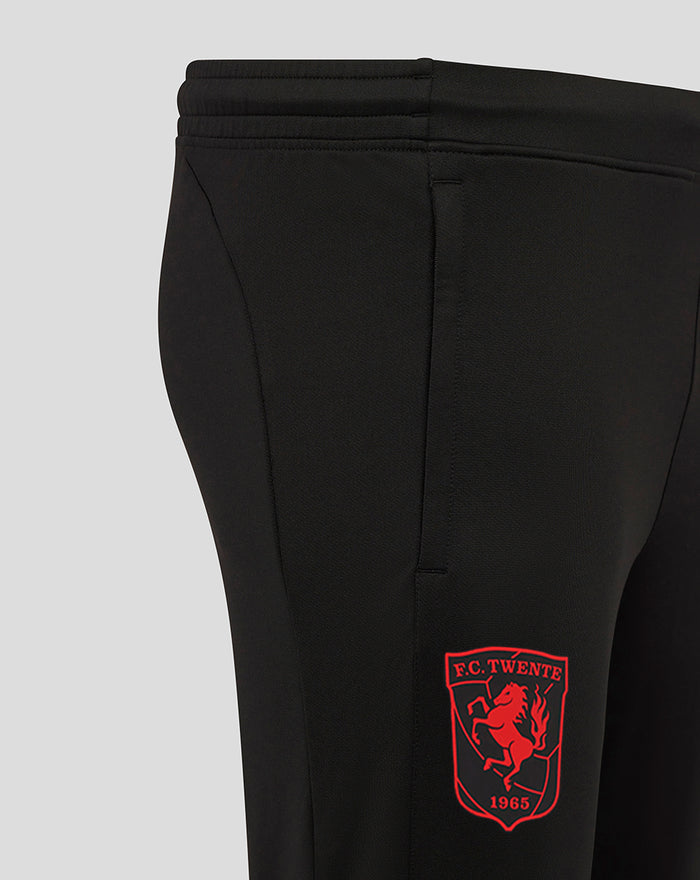 Close-up of the lower leg showing the FC Twente crest on black fabric with a zipper at the hem.