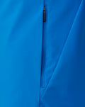 Close-up of bright blue FC Twente rain jacket showing a vertical zipper and smooth fabric.