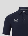 Front view of navy polo featuring a large winged emblem and Castore branding on the chest
