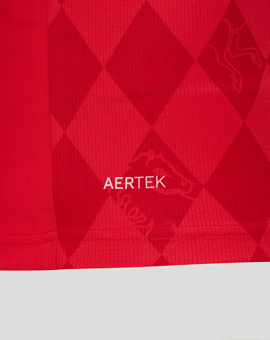 Close-up of red Twente home shirt fabric with AerTek branding and subtle diamond pattern