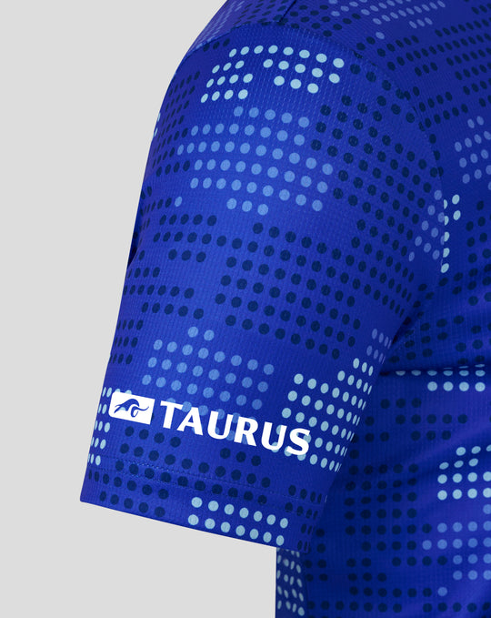 Detailed view of the blue shirt fabric with a dotted print and the Authentic Castore Product badge on the chest