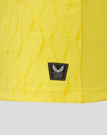 Lower hem area of yellow FC Twente keeper shirt with authentic Castore product badge and textured fabric.