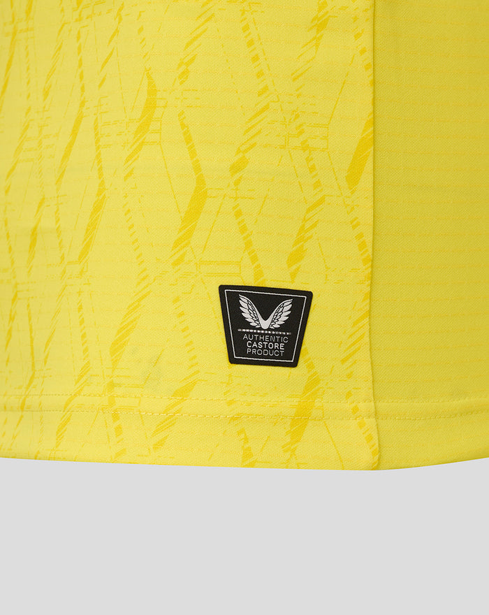Lower hem area of yellow FC Twente keeper shirt with authentic Castore product badge and textured fabric.