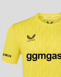 Upper section of yellow FC Twente keeper shirt showing crest, diagonal textured pattern and collar detail.